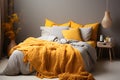 Yellow and beige pillows and knitted blanket on bed in natural bedroom interior with wooden bedside table Royalty Free Stock Photo