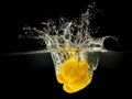 Yellow bell pepper falling in water with splash on black background Royalty Free Stock Photo