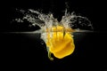 Yellow bell pepper falling in water with splash on black background Royalty Free Stock Photo