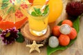 Yellow beverage in glass vessels surrounded by tropical fruits Royalty Free Stock Photo