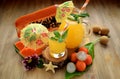 Yellow beverage in glass vessels surrounded by tropical fruits Royalty Free Stock Photo