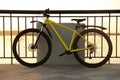 Yellow bicycle parked near railing on city waterfront