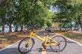 Yellow bicycle on road through at green park. Royalty Free Stock Photo