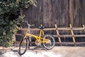 Yellow bicycle on vintage wooden house wall Royalty Free Stock Photo