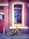 Yellow bike and brick building