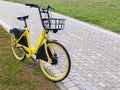 Yellow bike with food basket standing on grass near footpath Royalty Free Stock Photo