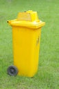 A yellow bin in the park