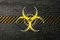 Yellow biohazard sign on the background of a concrete wall and a protective tape