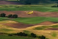 Yellow Biplane Crop Duster Flying Over Farmlands. Royalty Free Stock Photo