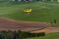 Yellow Biplane Crop Duster Flying Over Farmlands. Royalty Free Stock Photo