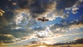 Yellow biplane flying into a cloudy sky at sunset Royalty Free Stock Photo