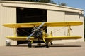Yellow biplane in front of hangar Royalty Free Stock Photo