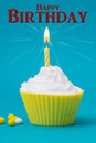 Yellow birthday cupcake with burning candle