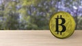 Yellow bitcoin gold coin on wood wooden table over forest trees blur. bit-coin 3d render isolated, cryptocurrency, crypto,