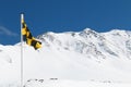 Yellow and black avalanche risk warning flag flying in the mount Royalty Free Stock Photo