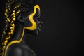 Woman on abstract poster with gold face art. Yellow and black body paint. Young girl with bodypaint. An amazing model