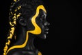 Yellow and black body paint. Woman with face art. Young girl with colorful bodypaint. An amazing afro american model Royalty Free Stock Photo
