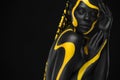 Yellow and black body paint. Woman with face art. Young girl with colorful bodypaint. An amazing afro american model Royalty Free Stock Photo