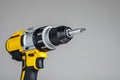 Yellow-black cordless Combi Drill on gray background
