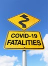 A yellow and black COVID-19 Fatalities warning sign with curvy upward arrow in a blue sky Royalty Free Stock Photo