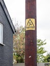 A yellow and black danger of death sign with electric bolt and m