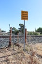 A yellow and black Do Not Cross, Trespassers Prosecuted warning sign at a disused railway station Royalty Free Stock Photo