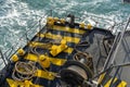 The deck of the ferry boat along with the a thick mooring rope and blue sea water wave, Thailand. Close up Royalty Free Stock Photo