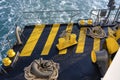 The deck of the ferry boat along with the a thick mooring rope and blue sea water wave, Thailand. Close up Royalty Free Stock Photo