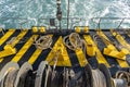 The deck of the ferry boat along with the a thick mooring rope and blue sea water wave, Thailand. Close up Royalty Free Stock Photo