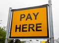 Yellow and black pay here sign at a car park Wigan Lancashire July 2019 Royalty Free Stock Photo