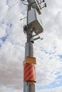 Yellow/black and yellow/red caution and hazard signs in a power pole warning of live electricity cables underground