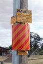 Yellow/black and yellow/red caution and hazard signs warning of live electricity cables underground