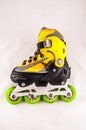 A yellow and black roller skate with green wheels