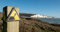 Sign warning of the danger of erosion at the cliff edge overlooking Seven Sisters at Seaford in East Sussex, south coast of UK Royalty Free Stock Photo