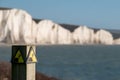 Sign warning of the danger of erosion at the cliff edge overlooking Seven Sisters at Seaford in East Sussex, south coast of UK Royalty Free Stock Photo