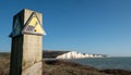 Sign warning of the danger of erosion at the cliff edge overlooking Seven Sisters at Seaford in East Sussex, south coast of UK Royalty Free Stock Photo