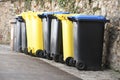 Yellow and black trash containers in a row