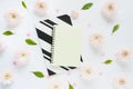 yellow and black and white striped notebooks, we hold a heart and many pink flowers of chrysanthemums and green leaves on a white