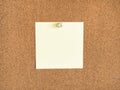 Yellow blank note paper pinned to corkboard Royalty Free Stock Photo