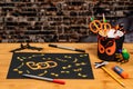 Yellow Bloodshot eyes covering a black sign for Halloween.  Other crafts and supplies scattered on the table. Negative space for Royalty Free Stock Photo