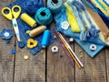 Yellow and blue accessories for needlework on wooden background. Knitting, embroidery, sewing. Small business. Income from hobby. Royalty Free Stock Photo