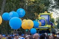 Yellow and blue balloons during the Madrid Pride Parade with crowd walking on the street