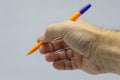 Yellow with a blue fountain pen in hand close-up on a light background. Royalty Free Stock Photo