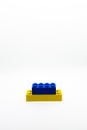 Yellow and blue lego brick or block isolated on white background