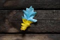 The yellow-blue national flag of Ukraine is painted on a leaf of an oak tree lies on a wooden table. Peace in Ukraine Royalty Free Stock Photo