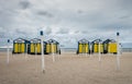 Yellow and blue painted beach huts on the beach of De Panne in Belgium.