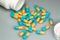 Yellow and blue pills spilling out of a white bottle on the pharmacy table Royalty Free Stock Photo