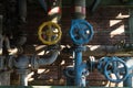 Several Yellow and blue pipes and valve handle wheel at the abandonned blast furnace at Duisburg Landschafts Park Germany