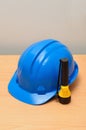 A yellow and blue plastic flashlight with a blue hard hat Royalty Free Stock Photo
