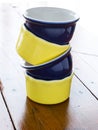 Yellow and blue ramekins stacked on wooden table. Royalty Free Stock Photo